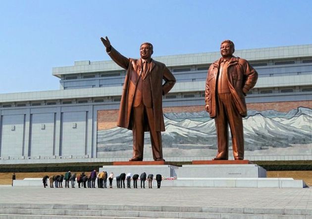 Visiteurs s'inclinant devant les statues de Kim Il-sung et Kim Jong-il